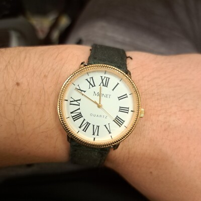 Monet Unisex Gold Tone Roman Numeral Quartz Black Buckle Band Analog Watch