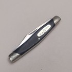 Black-handled Buck 309 slipjoint pocket knife with silver bolsters and engraved oval case on a light background.
