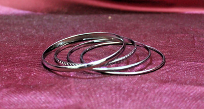 Four dark gray metal stacking bangles