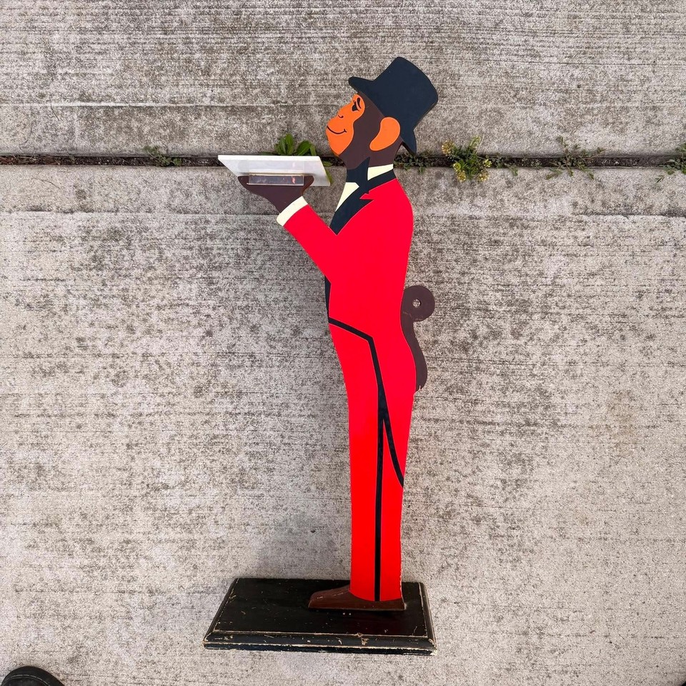 A 33" tall 1984 wooden monkey butler drink valet — a gloriously absurd mid-century novelty that holds your cocktail while judging you silently.