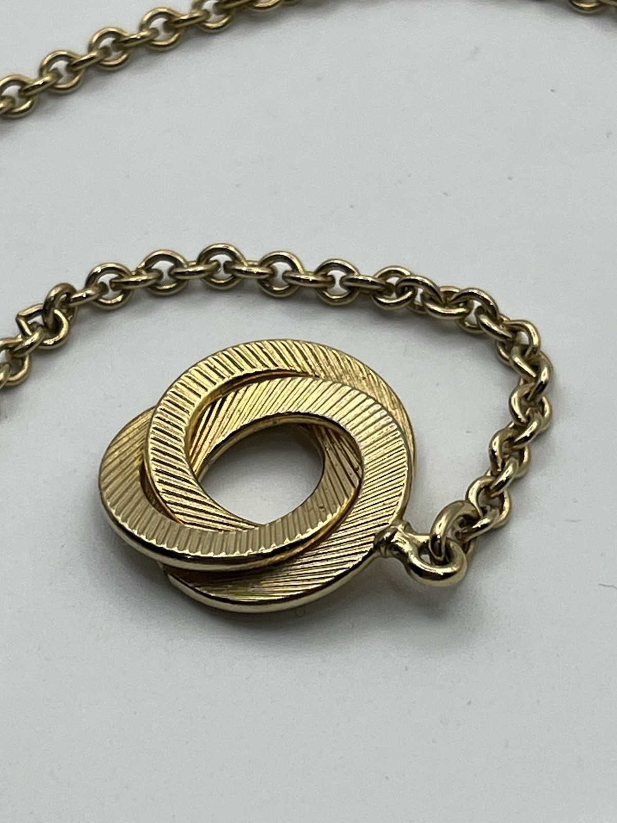 Engine turned gold tone triple interlocking circl… - image 12