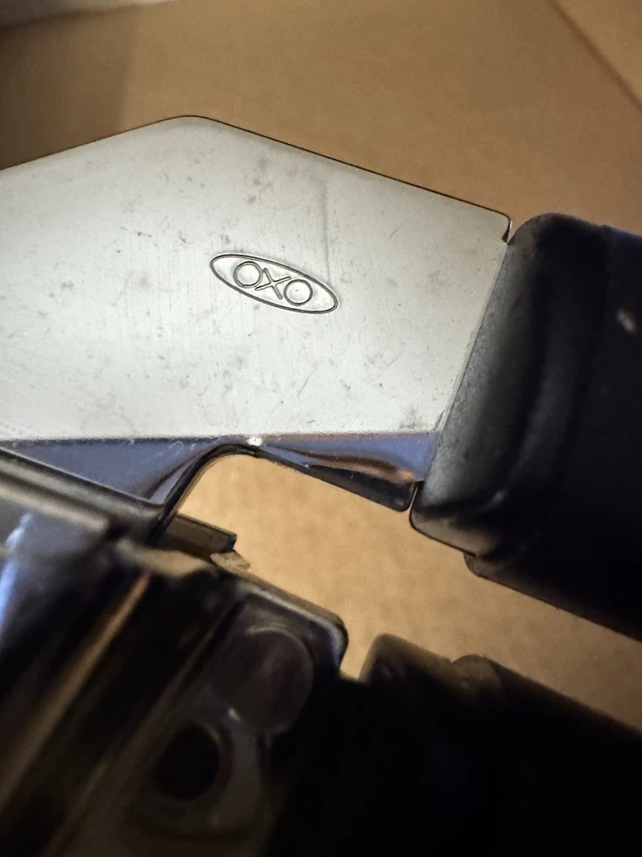 Prensa de ajo de acero inoxidable de metal premium OXO de 7,5" L Foto 3 de 4