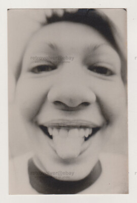 Unconventional Woman Grins and Sticks Out Tongue in Close-Up Camera Snapshot