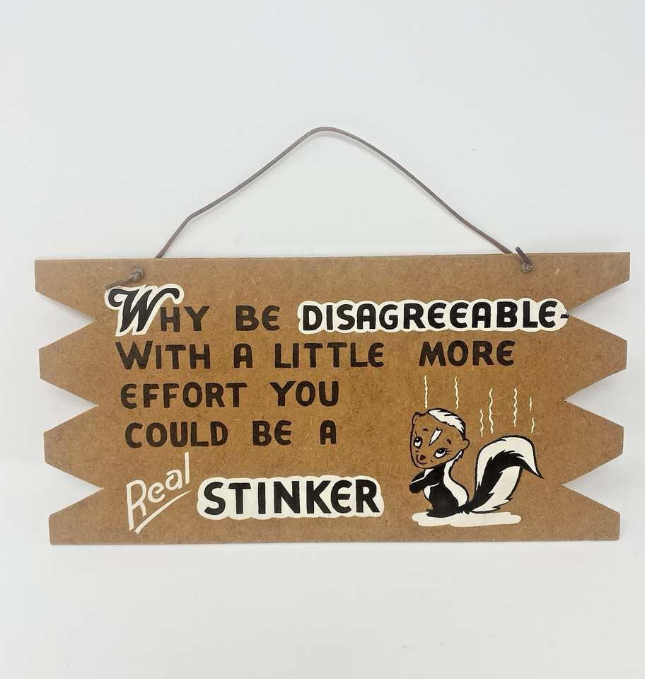 A genuine vintage Western Artcraft skunk sign — the kind of dry, self-aware humor that looks perfectly at home in a man cave without trying too hard.