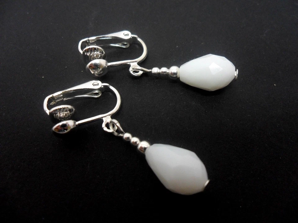 A PAIR OF WHITE GLASS CRYSTAL TEARDROP CLIP ON EARRINGS. NEW. - Image 1 of 1