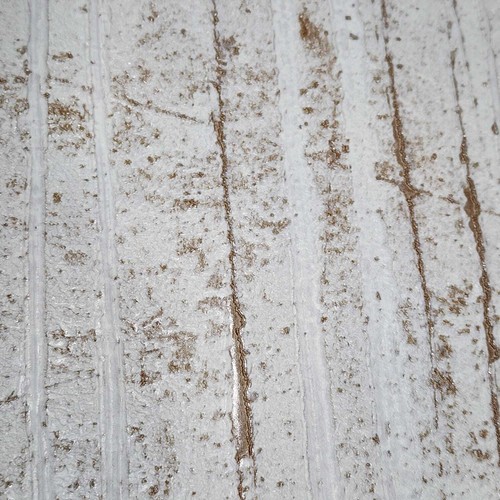 Off white textured wallpaper with cracks in gold metallic lines, featuring subtle rust spots on a textured light surface.