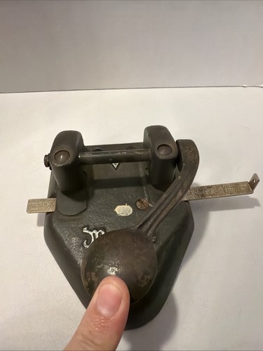 Vintage black cast iron punch with dual horizontal levers and gold “Wilson Jones Marvel 60 Hole” text on side.
