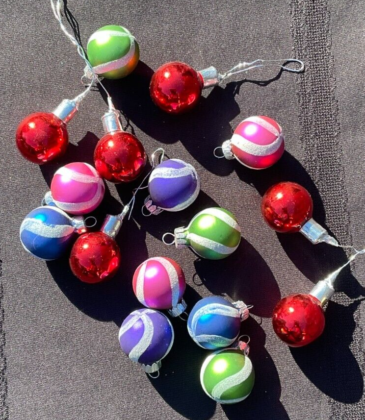 Lot of 16 round Christmas balls with multicolor horizontal stripes in red, red-green, and red-purple on a black background.