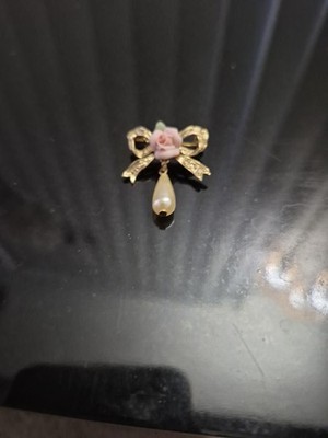 Este es un broche de la colección Vintage 1928 con un lazo, flor de rosa