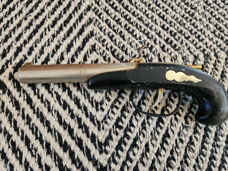 vintage flintlock or derringer-style pistol-shaped cigarette lighter