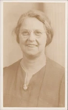 Woman with Eyeglasses and Pinstripe Suit Smiling at Studio RPPC Postcard