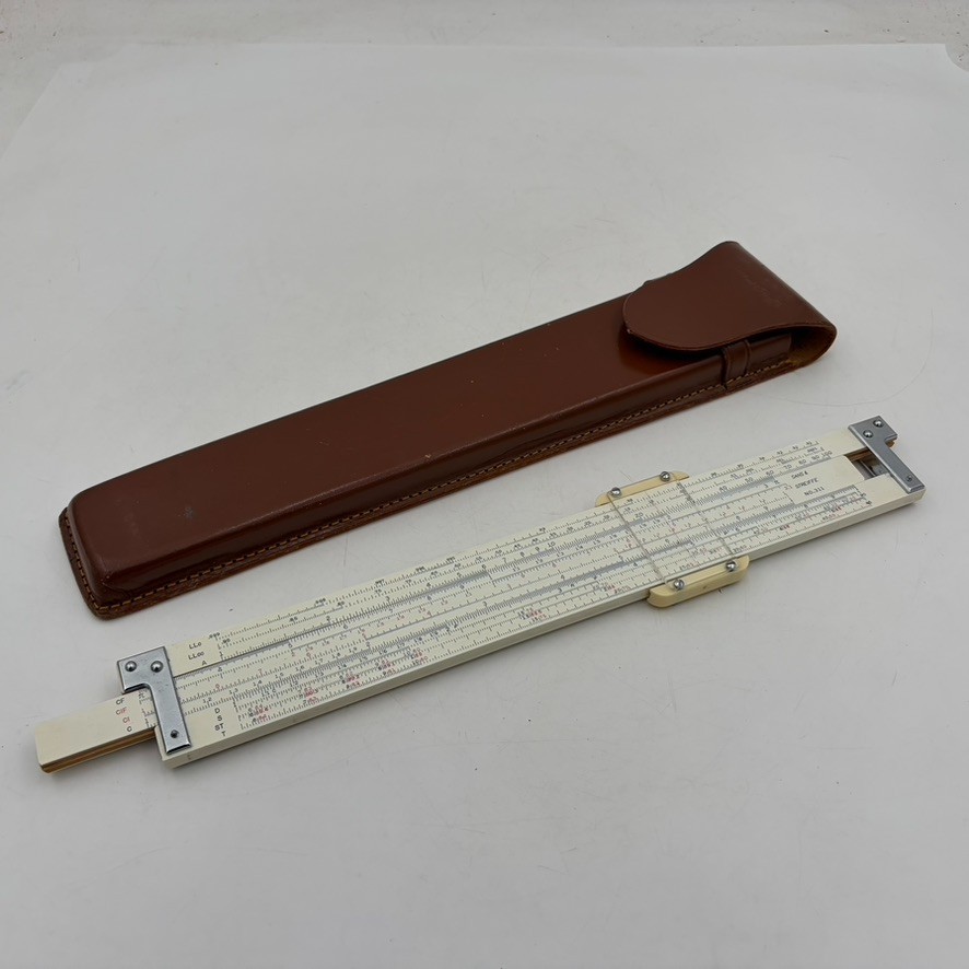 A draftsman's slide rule in its original leather case — evokes the golden age of hand-calculated engineering blueprints.