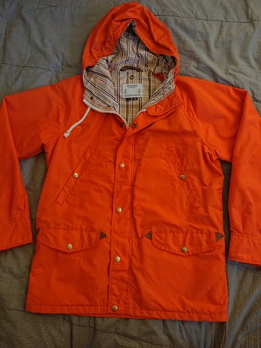 Orange cotton-nylon 70s-style vintage parka with hood, front buttons, and plaid-lined inner pockets.