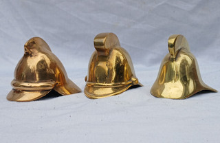 A Trio of Cast Brass Firemans Helmets