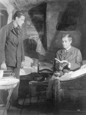 Two men share a room one reading and the other deep in thought - 1925 Old Photo