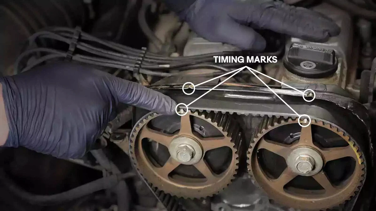 Mechanic verifying that the cam gears and crank timing marks are aligned.