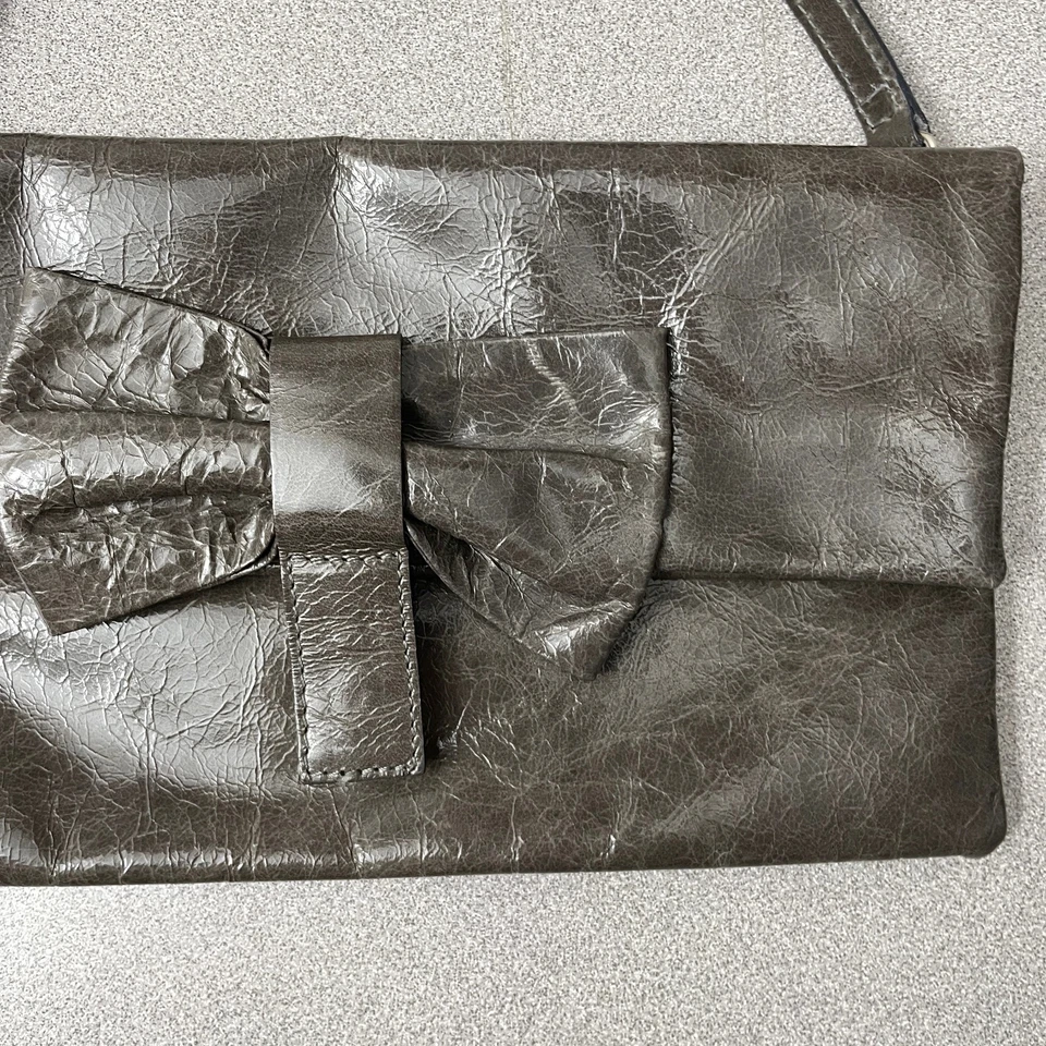 Bolso sin asas Gianni Chiarini de cuero marrón con correa de moño a presión bolso de muñeca brillante Foto 2 de 4