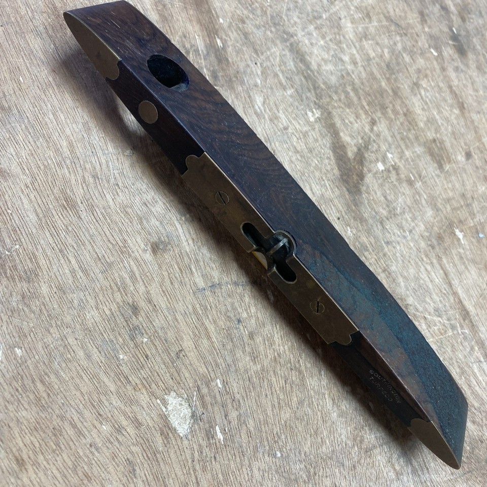 A wood-and-brass torpedo level from Southington Hardware Co. — genuinely antique, visually stunning, and the kind of desk object that makes every visitor ask 'where did you get that?'