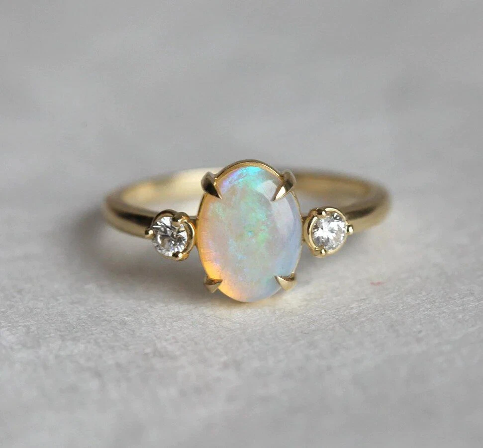 Engagement ring with 2024 opal side stones