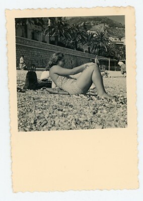 PHOTO SNAPSHOT, a woman in a jersey on a pebble beach in profile