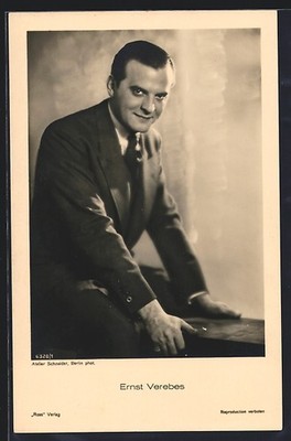 Postcard actor Ernst Verebes sitting on a wall 