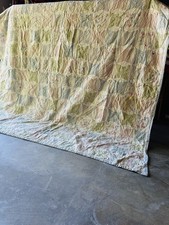 A handmade vintage patchwork quilt with floral and gingham fabrics.