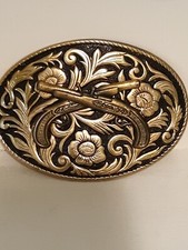 Belt buckle Crossed guns flower background gold color.