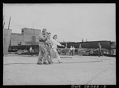 Shipyard Workers Trio Walking Amid Ship Construction 1910s Industrial Scene