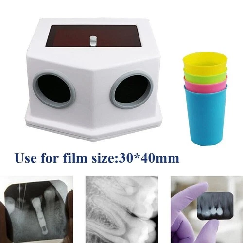 White portable dental X-ray film processor box with two circular windows, surrounded by four pastel-colored cups.