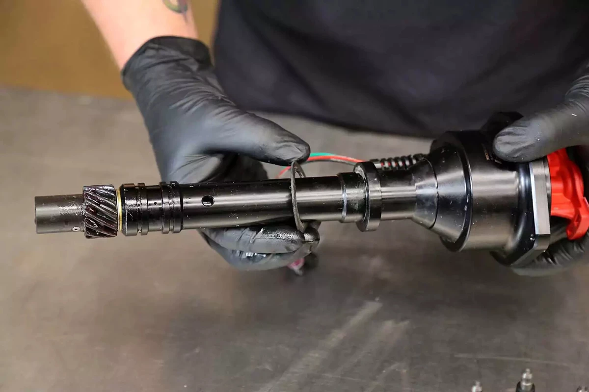A mechanic slides a gasket onto the base of the new distributor.