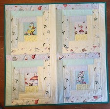 Quilted Table topper made in a Log cabin with spring, and Easter fabric. 24"x24"