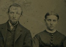 SULTRY EYED WOMAN WITH BEARDED MAN. TINTYPE IN PERIOD PAPER MAT.