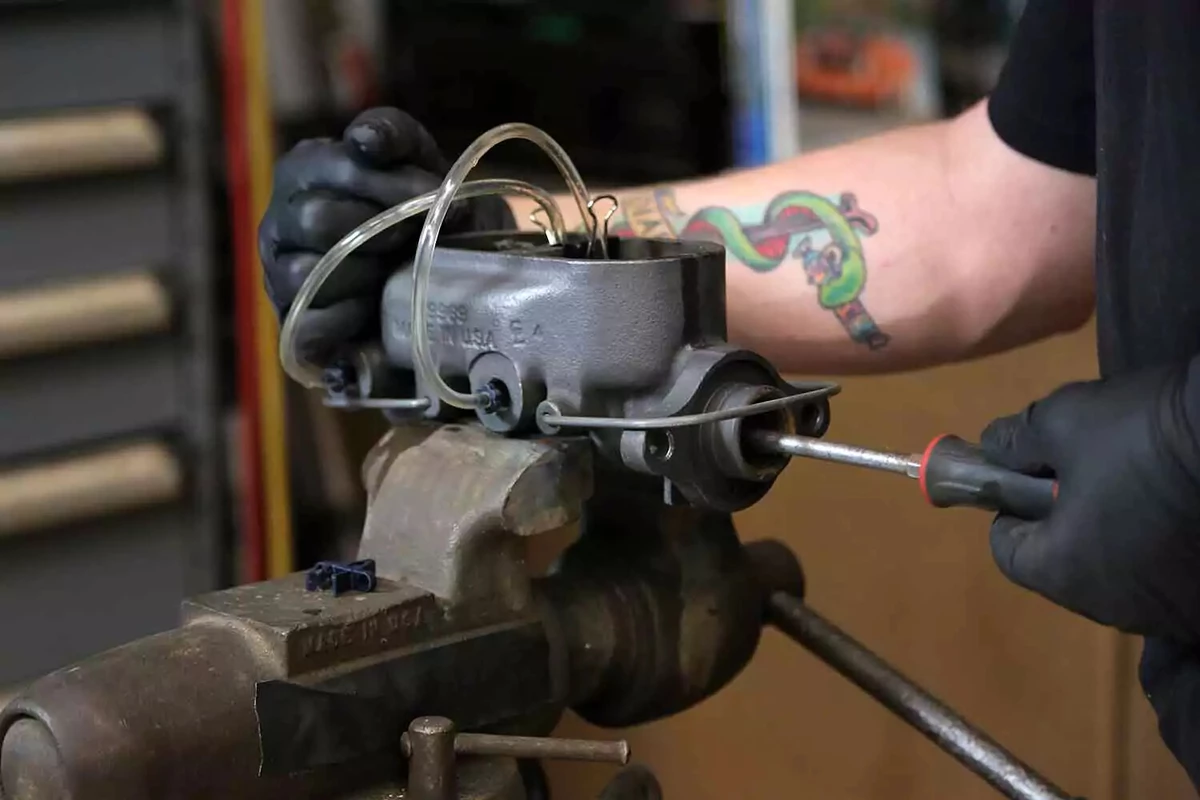 Bleeding the new master cylinder held with a vice on a bench.
