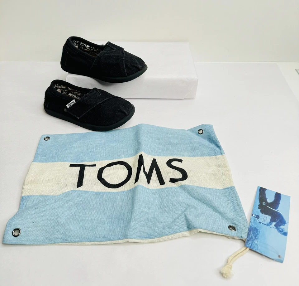 Zapatos planos informales de lona sin cordones negros pequeños Toms Classics para niños pequeños Foto 2 de 4