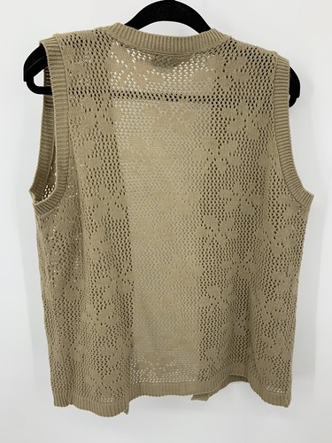Beige open-front knit sweater vest with floral lace pattern and scalloped edges, displayed on black hanger.