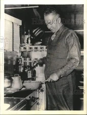 1937 Press Photo Cornelius Vanderbilt, Jr. cooks inside his trailer in NY