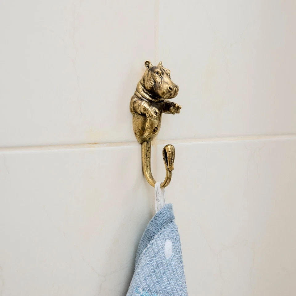 Un gancho de pared para ropa está hecho de latón en forma de hipopótamo. Foto 2 de 4