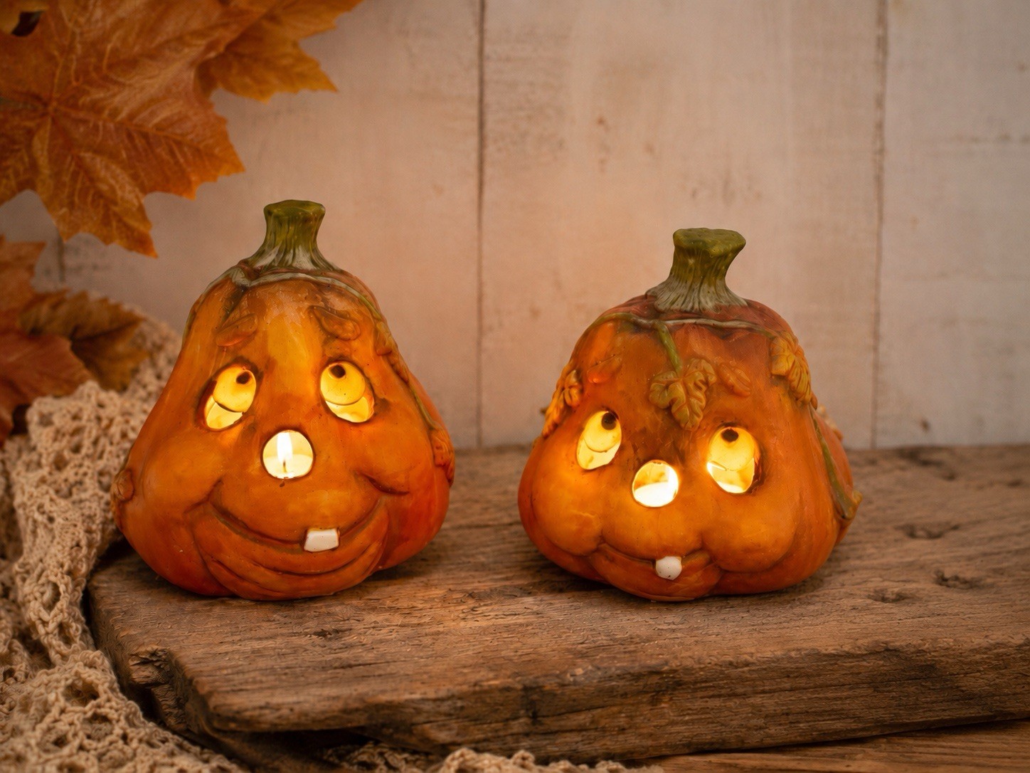 A pair of ceramic pumpkin-shaped tealight holders.