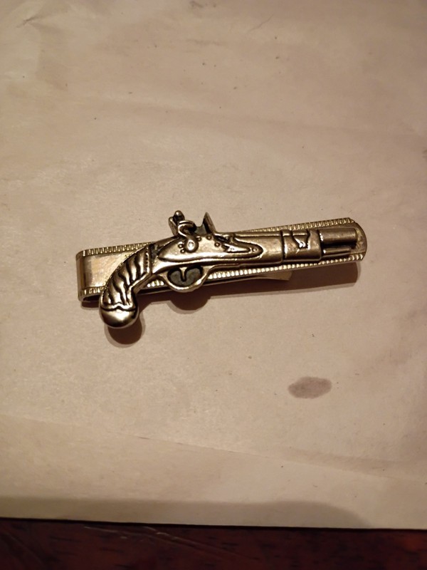 Silver Money Clip Showing A Gun