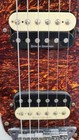 Black SQUIER VATAGE MOD Jager electric guitar with white pickguard, silver hardware, and orange-brown textured finish.