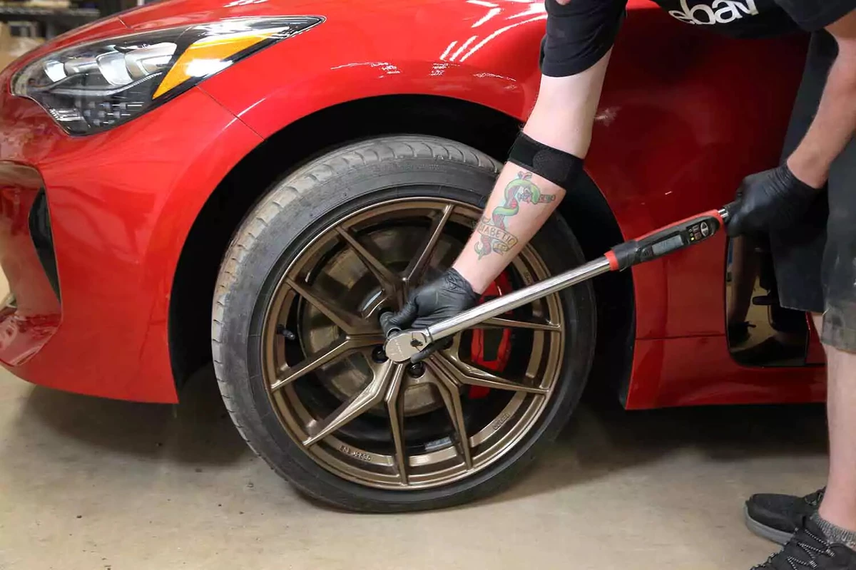 A mechanic tightens the lug nuts to factory specifications.