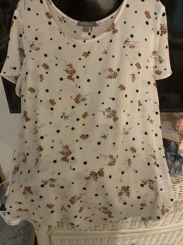 Peace & Pearls white top features a black polka dot and floral pattern.