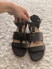 Elegant black sandals with gold accents. Perfect for casual or dressy occasions.