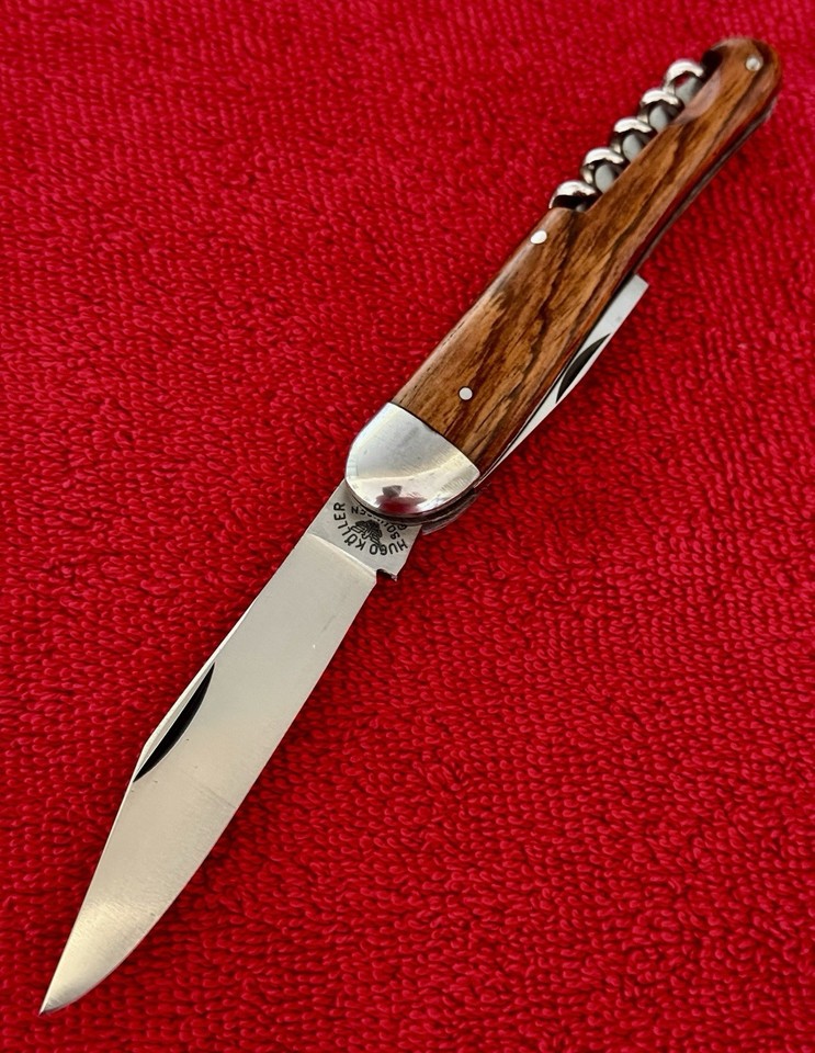 A stunning Hugo Köller Solingen-made camp multi-tool with wooden scales and corkscrew — German craftsmanship from an era when pocket tools were art objects.