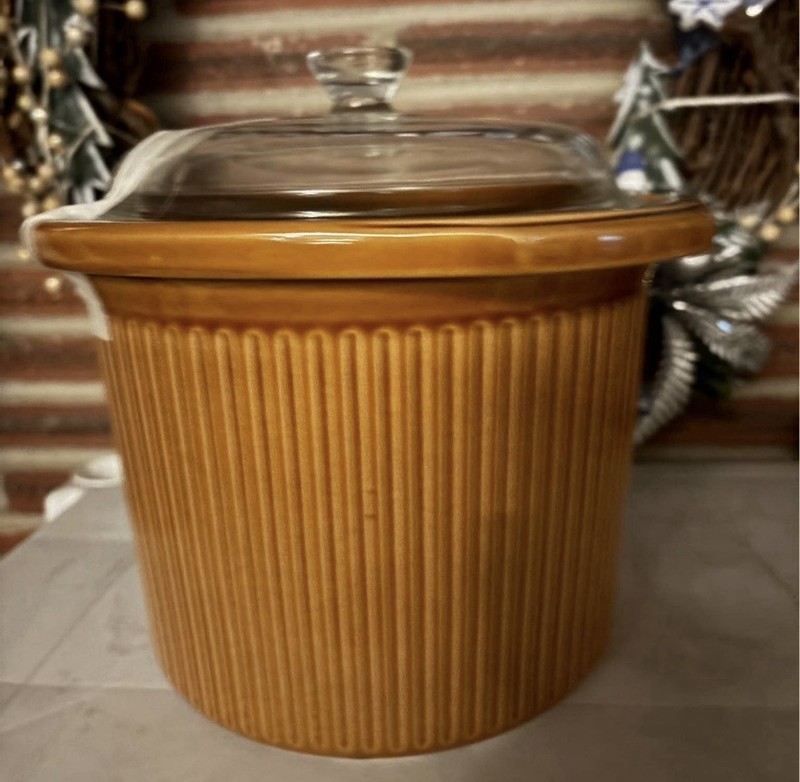 1970s Rival Crock-Pot, often brown ribbed stoneware with a glass lid.