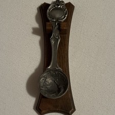 Zinn-Zierl&ouml;ffel mit Reliefmotiv Mensch auf Holzbrett mit Wandhalter