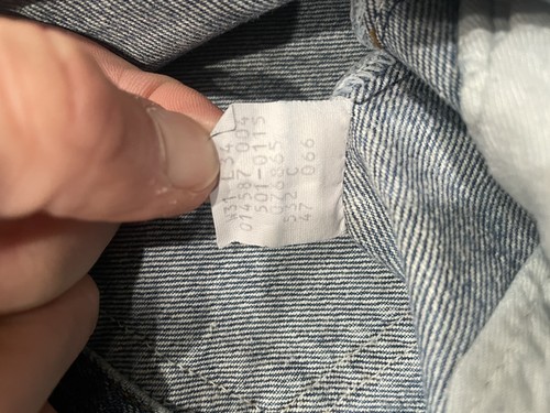White vintage Levi’s 501XX Blue made in USA tag with green seal, showing size 31x34 and product details on fabric.