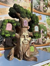 Beautiful fairy tree house ornament with colourful doors and a magical tree face
