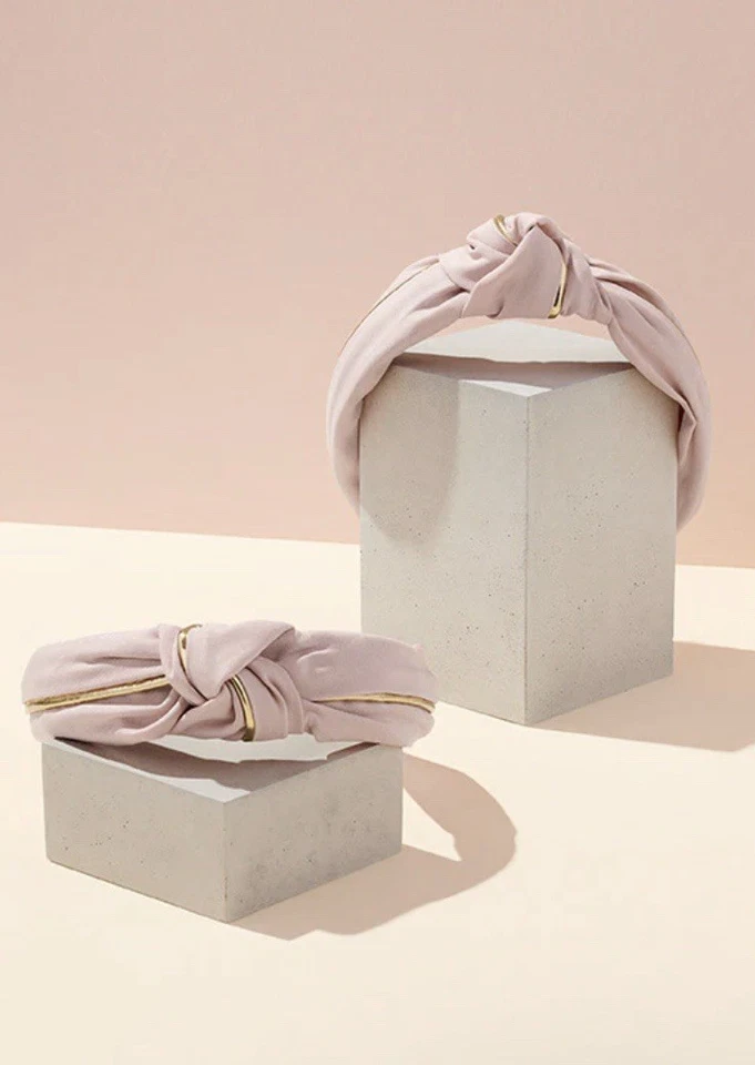 Diadema de tela anudada en rosa pastel con tubería dorada Foto 2 de 4