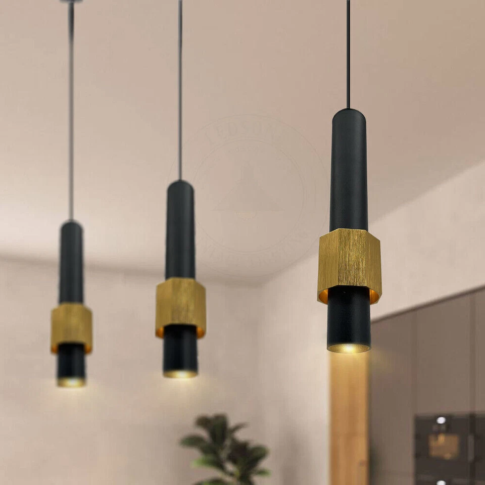 Black cylinder pendant light hanging over a modern kitchen island
